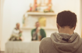 joven orando misa